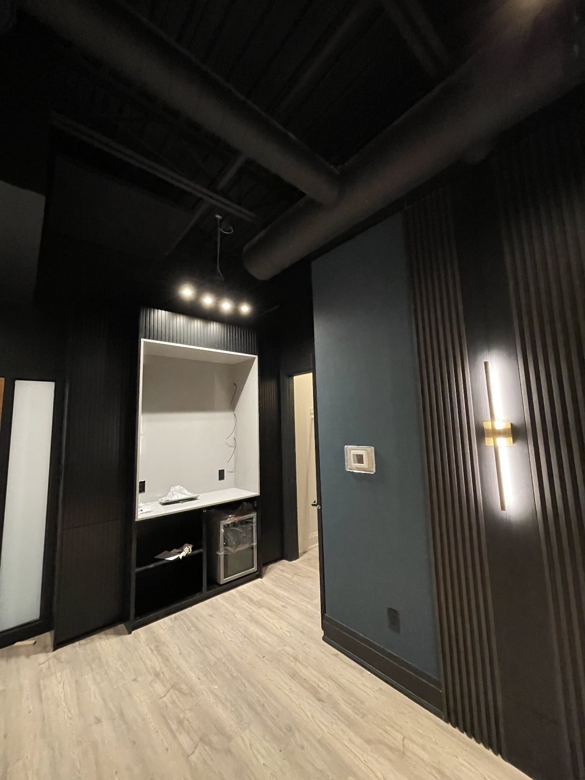 Phone-booth nook — task lighting over the desk, dedicated circuit for fridge and accessories below.